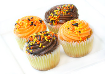 Chocolate and Orange Iced Cupcakes on White.