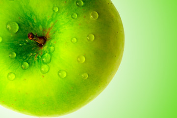 green apple in dewdrop on green background