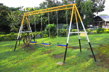 three seat swing in a children's playground.
