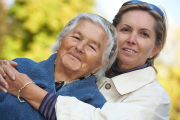 Middleaged woman with her elderly mother. Focus on the daughter.