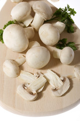White button mushrooms on wooden cutting board