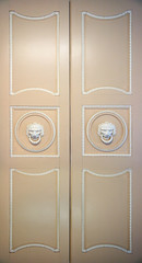 old closed ornate doors with lion head handles