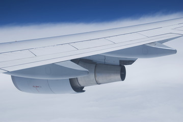 Wing and jet engine of passenger airplane flying.