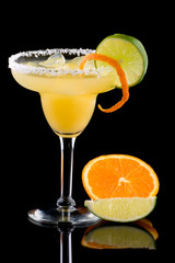 Orange Margarita in chilled glass over black background