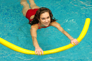 young woman  is swimming with aqua noodles
