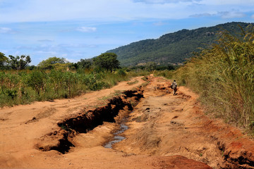 a man walking on a road to nowhere in Africa