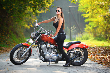 Naklejka na ściany i meble Attractive girl on a motorbike