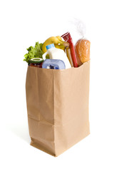 A brown kraft bag full of groceries including, milk, eggs