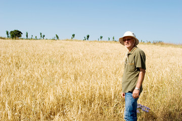 Naklejka na ściany i meble Farmer man working at a wheat field