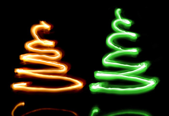 Two sparkler Christmas trees over black background