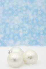 Silver glass Christmas balls on snowflake background