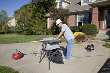 Carpenter cutting wood needed to replace rotten wood