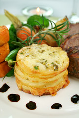 Baked lamb and potato stack with onions and beans