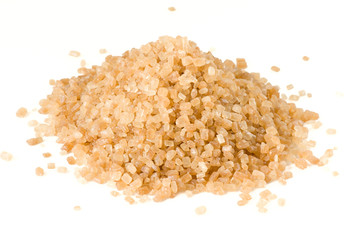 Heap of brown cane sugar isolated on white, macro lens shot