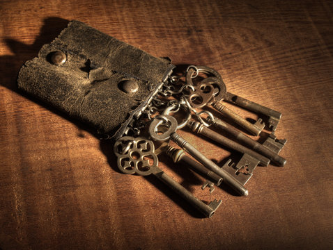 An Old Leather Keyring Over A Wooden Table.