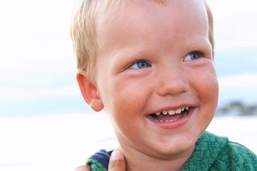 Small boy portrait on evening sandy sea coast