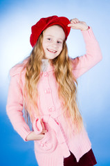 Smiling little girl in red cap, studio shot