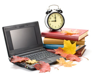 Pile of books, notebook and autumn leaves on a white background.