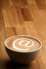 A cappuccino with an @ sybol in the milk