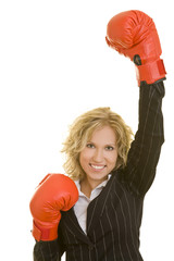 Blonde Frau im Jackett mit roten Boxhandschuhen jubelt