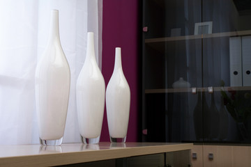 Vases in the form of bottles on a background of a window