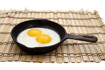 two eggs on black cast iron pan