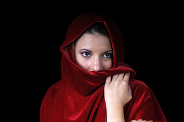 Beautiful young brunette woman up with red shawl over face