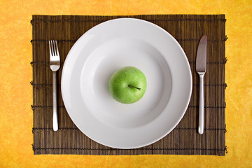 white dish and green apple on bamboo board
