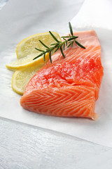 Salmon fillet, ready for cooking, with lemon and rosemary.