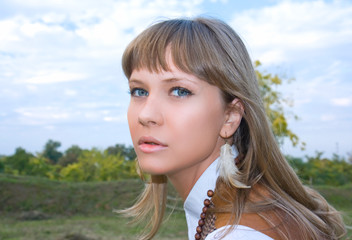 Portrait of the beautiful young girl against green foliage