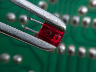 Red LED in pincers elctronic assembly macro