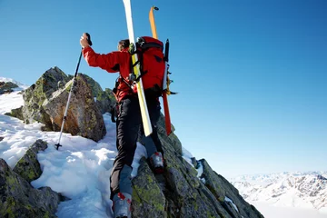 Foto op Canvas Male ski-climber climbing a rocky ridge  horizontal frame. © rcaucino