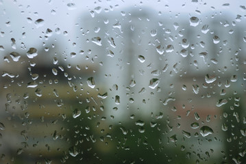 rain drops on a window and mystic silhouette of city