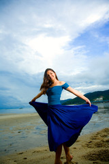 young eurasian woman at the sunset beach flipping her skirt