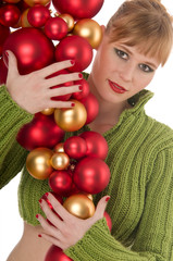 Fototapeta na wymiar Young model in green sweater holding bunch of Christmas balls