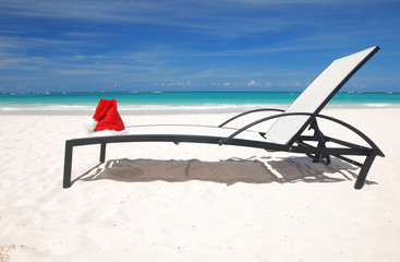 Santa's hat and chaise lounge on the beach