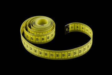 yellow tape measure isolated on black background