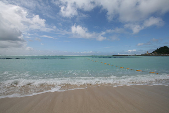 waves of bay with castle and observatory of okinawa japan