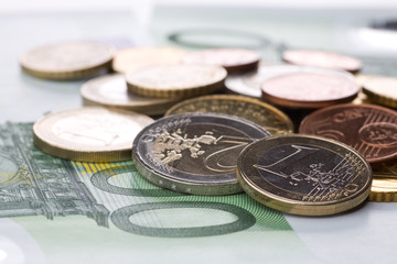 Verschiedene Euromünzen liegen auf 100 Euro Geldschein