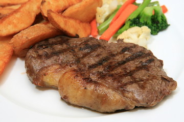 Sirloin steak with potato wedges and vegetables