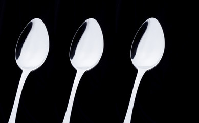3 silver spoon on a black background