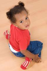 Adorable african baby sit over wooden floor