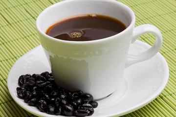 Cup of expresso coffee on a green tablecloth