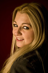 Fototapeta premium Portrait of a young blond woman on red background