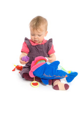 Cute baby girl (1 year old) sitting on floor playing