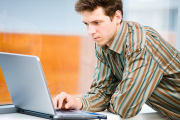 Casual looking businessman working on laptop computer