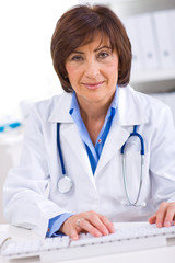 Senior female doctor working on computer at offiice.