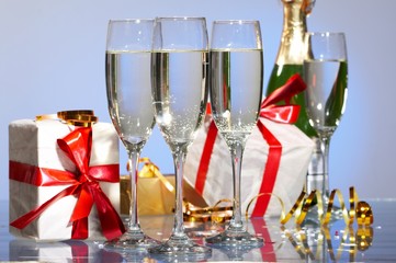 Glasses of champagne, gifts with red tapes and bows