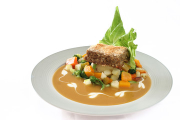 Gourmet meatloaf on a bed of vegetables
