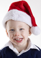 Handsome young child wearing a red santa claus hat